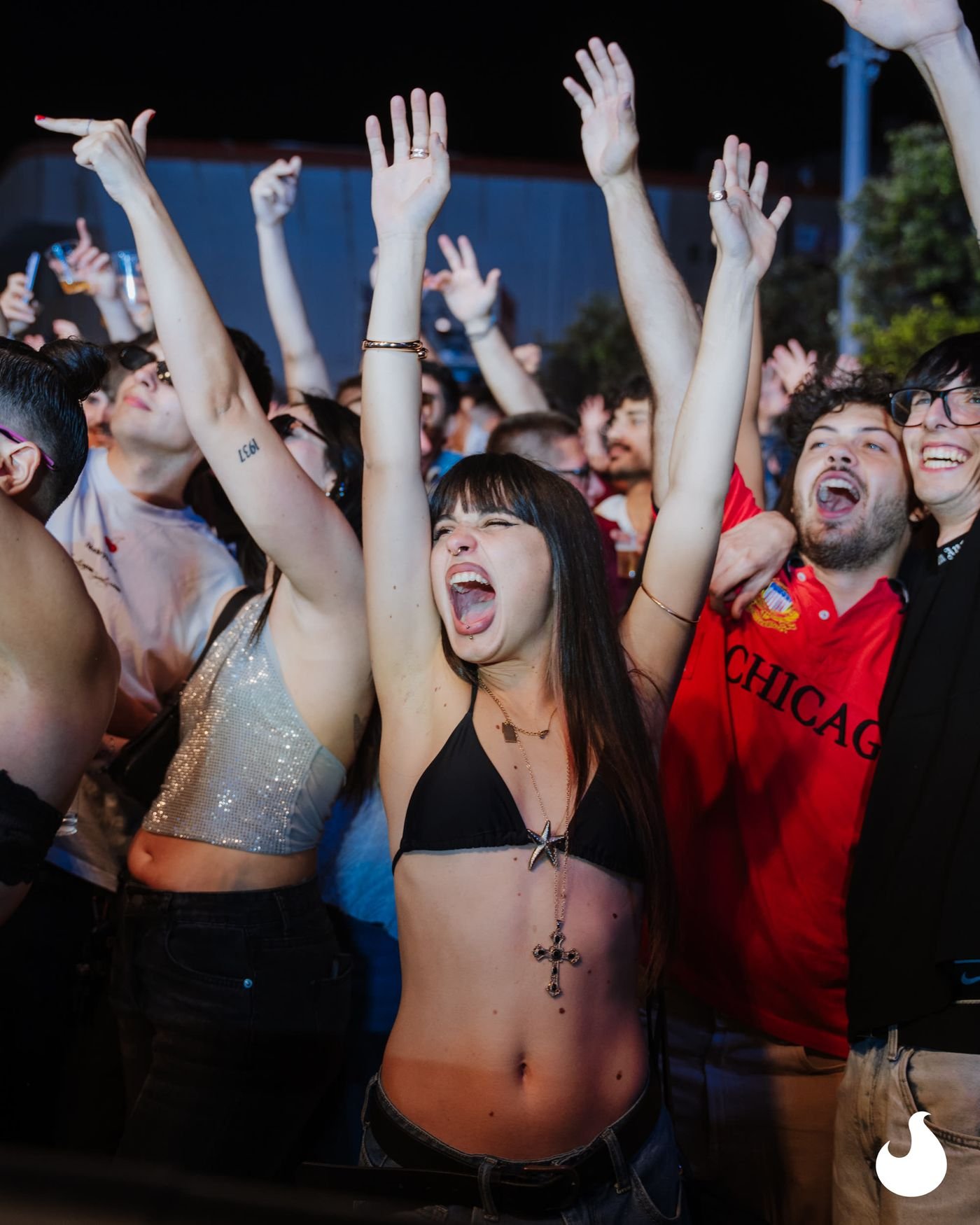 Ragazze che cantano con le mani alzate sotto il palco.