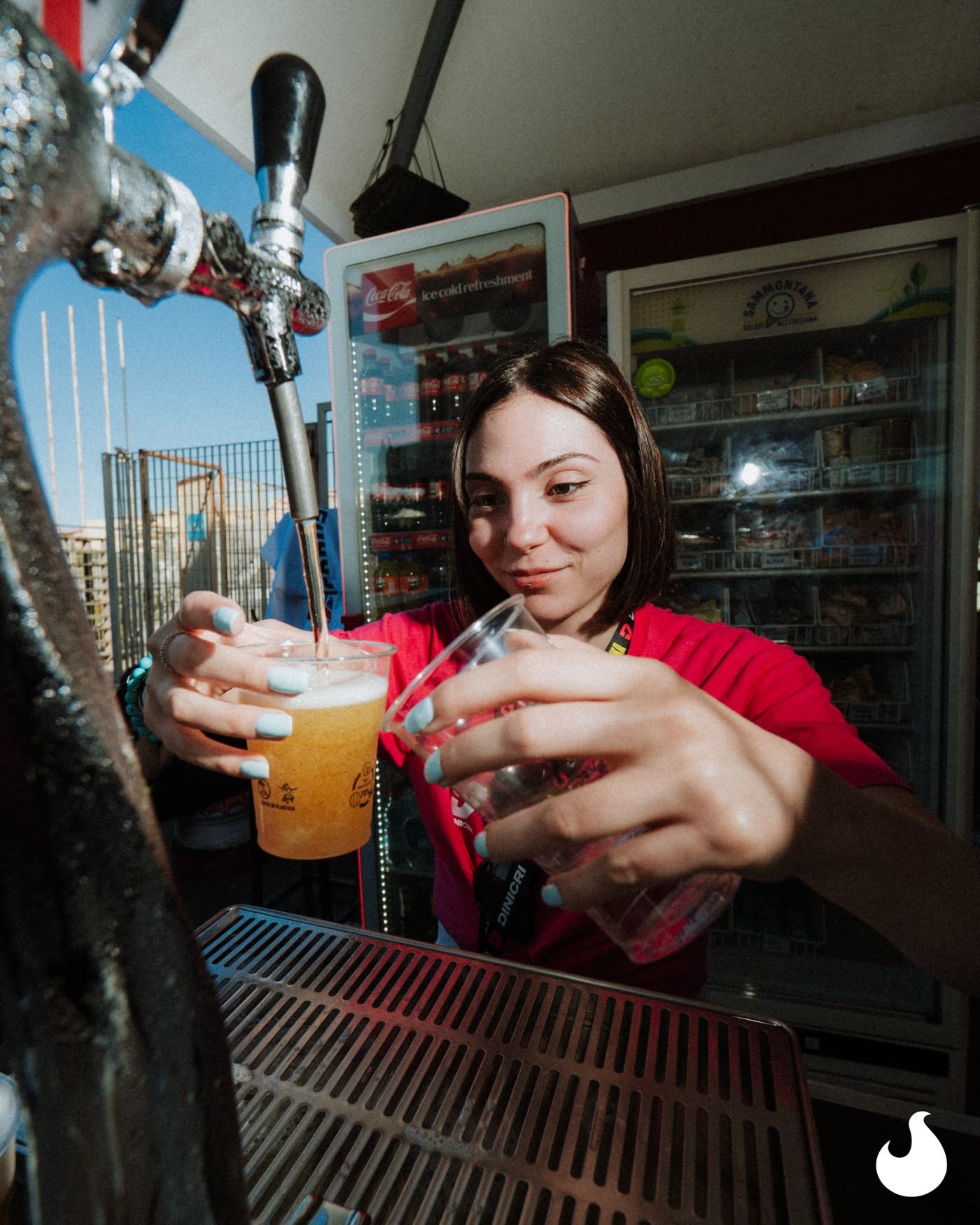 Una ragazza spilla una birra al banco del festival.