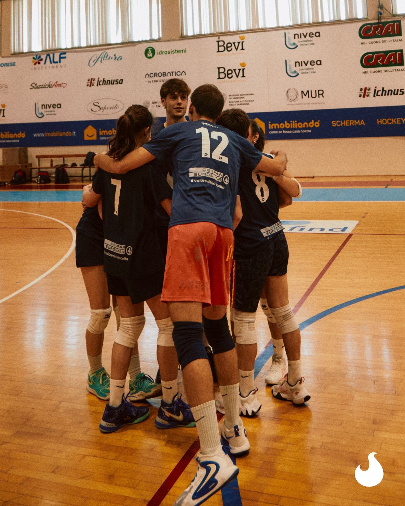 Una squadra di pallavolo raccolta in cerchio prima del punto.
